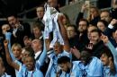 Manchester City captain Vincent Kompany raises the trophy after winning the English League Cup final soccer match between Liverpool and Manchester City at Wembley stadium in London, Sunday, Feb. 28, 2016. (AP Photo/Tim Ireland)