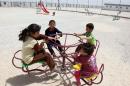Syrian refugee children play in the park of the UAE funded Mrajeeb Al-Fhood refugee camp, east of the Jordanian city of Zarqa, on April 15, 2013