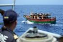 This handout picture taken by the French Navy on May 20, 2015 shows a crew member of the Commandant Birot patrol looking at migrants aboard a fishing boat during a rescue operation in the Mediterranean Sea