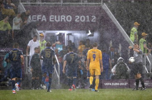 Match referee Bjorn Kuipers of Nederlands sends Ukraine's and France's players to the dressing rooms after suspending the Group D Euro 2012 soccer match due to a heavy storm at the Donbass Arena in Donetsk