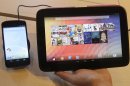 The Nexus 4 smartphone, left and the Nexus 10 tablet are shown by Randall Safara of Google at a Google announcement in San Francisco, Monday, Oct. 29, 2012. Google is adding a few more gadgets to holiday shopping lists. The devices announced Monday include the latest in Google's line of Nexus smartphones and a larger version of the 7-inch tablet that the company began selling in July under the Nexus brand. (AP Photo/Jeff Chiu)