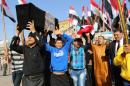 Protesters chant anti-Iraqi government slogans as they carry a box mimicking a coffin during a protest against the Iraqi parliament at Tahrir Square in Baghdad, Iraq, Saturday, March 8, 2014. (AP Photo/Karim Kadim)
