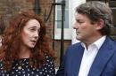 Rebekah Brooks, left, former News International chief executive, looks at her husband Charlie, right, as she talks to members of the media in central London, Thursday, June 26, 2014. Brooks was acquitted after a long trial centering on illegal activity at the heart of Rupert Murdoch's newspaper empire but Former News of the World editor Andy Coulson was convicted of phone hacking. The nearly eight-month trial was triggered by revelations that for years the News of the World used illegal eavesdropping to get stories, listening in on the voicemails of celebrities, politicians and even crime victims. (AP Photo/Lefteris Pitarakis)