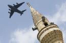 File photo of a U.S. Air Force Boeing C-17A Globemaster III large transport aircraft flies over a minaret after taking off from Incirlik air base in Adana