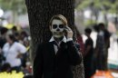 Fine arts student wears make-up as he talks on the phone during the Catrina's parade in Guadalajara
