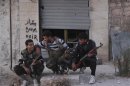 Free Syrian Army fighters react as they sit together along a street in Kansafra in Idlib province