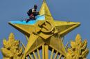 A worker repaints a star yellow at the top of a Stalin-era skyscraper in Moscow blue, on August 20, 2014. The star was painted in yellow and blue, the Ukrainian national colors, by unknown people