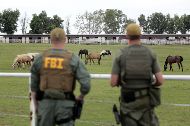 FILE - In this Tuesday, June 12, 2012 file photo, FBI agents overlook a horse ranch under investigation in Lexington, Okla. Prosecutors say a racehorse-buying operation was supposed to be a clandestine way for one of Mexico's most powerful and violent drug cartels to launder its illegal proceeds in the United States. But authorities reined in the operation partly because those who ran it didn't keep a low profile. At least four of the 18 individuals indicted in the scheme are set to be tried in an Austin, Texas, federal courtroom starting Monday, April 15, 2013. (AP Photo/Brett Deering, File)