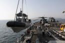 A U.S. Navy boat is lowered to the sea from the deck of the USS Ponce, a floating base to support mine countermeasure operations, in the Persian Gulf on Saturday, Sept. 22, 2012. More than 30 nations are participating in an exercise responding to simulated sea-mine attacks in international waters _ a demonstration of international resolve to ensure maritime security in the strategic but volatile region. (AP Photo/Hasan Jamali)