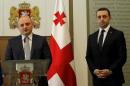 Mindia Janelidze the newly appointed Georgian Defense Minister, left, speaks during a news conference in Tbilisi, Georgia, Nov. 5, 2014. Georgian Prime Minister Irakli Garibashvili, right, said that he has dismissed former Defense Minister Irakli Alasania. The resignation of Foreign Minister Maya Panjikidze on Wednesday and the earlier firing of Defense Minister Irakli Alasania increases Georgia's political instability as it pursues closer ties with the West. (AP Photo/Shakh Aivazov)
