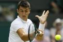 Bernard Tomic of Australia returns a ball to Novak Djokovic of Serbia during their singles match at the All England Lawn Tennis Championships in Wimbledon, London, Friday July 3, 2015. (AP Photo/Kirsty Wigglesworth)