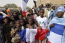 Children celebrate holding a French flag during reopening ceremony of Mahamane Fondogoumo elementary school in the town centre of Timbuktu