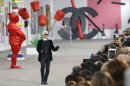 German fashion designer Karl Lagerfeld acknowledges applause following the presentation of the ready-to-wear Spring/Summer 2014 fashion collection he designed for Chanel, Tuesday, Oct. 1, 2013 in Paris. (AP Photo/Christophe Ena)