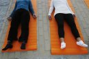 People take part in a free yoga class at a park in Madrid
