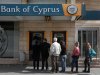 People queue up to make a transaction at an ATM outside a branch of Bank of Cyprus in Nicosia