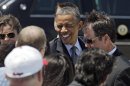 President Barack Obama greets supporters after arriving at Cleveland Hopkins International airport in Cleveland, Thursday, June 14, 2012, before attending a campaign event in the city. (AP Photo/Mark Duncan)