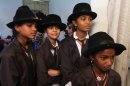 Indian girls wait for their turn to be made up to look like Charlie Chaplin to participate in the annual parade to celebrate his birthday in Adipur, Gujarat state, India, Tuesday, April 16, 2013. Canes in hand and bowler hats firmly in place, dozens of Charlie Chaplin impersonators tramped through the streets of this small port town in western India on Tuesday to celebrate the birthday of the legendary comic actor and filmmaker. (AP Photo/Ajit Solanki)