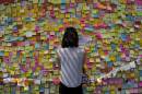 A woman looks at messages of support for pro-democracy demonstrations on a wall, as protesters block areas around government headquarters in Hong Kong