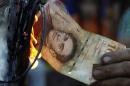 A man burns a 100-bolivar bill during a protest in El Pinal