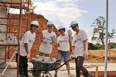 P&G volunteers transporting bricks to build walls on site