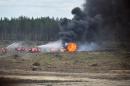 Firefighters extinguish a burning Russian military helicopter after it crashed during an aerobatic display in Dubrovichi, Russia, Sunday, Aug. 2, 2015, killing one of its crew members and injuring another. The Mi-28 helicopter gunship was part of a flight of helicopters performing aerobatics at the Dubrovichi firing range in Ryazan region, about 170 kilometers (105 miles) southeast of Moscow, when it crashed Sunday. (Anton Nasonov, RZN.info/Photo via AP)