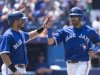 Toronto Blue Jays' Jose Bautista, right, and Melky Cabrera celebrate scoring on an RBI-double by Edwin Encarnacion against the Baltimore Orioles during third-inning baseball game action in Toronto, Sunday June 23, 2013. (AP Photo/The Canadian Press, Chris Young)