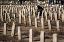 A woman visits the grave of a relative in the town of Douma, east of Syria's capital Damascus, in July