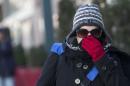 A woman lifts her scarf up in front of her nose to shield from the cold air, Friday, Feb. 12, 2016, in New York. The National Weather Service predicts temperatures well below freezing on Saturday for New York. But wind chills could drop even lower, and wind gusts could reach around 44 mph. (AP Photo/Mary Altaffer)