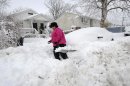 April Palmieri digs out her car in front of her home, background left, on 17th Street after a snow storm on Saturday, Feb. 9, 2013 in Bayville, N.Y. Palmieri had five feet of water in her basement as result of the rains from Superstorm Sandy. A howling storm across the Northeast left the New York-to-Boston corridor shrouded in 1 to 3 feet of snow Saturday, stranding motorists on highways overnight and piling up drifts so high that some homeowners couldn't get their doors open. More than 650,000 homes and businesses were left without electricity. (AP Photo/Kathy Kmonicek)