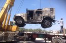 The charred remains of an armored vehicle are loaded onto a trick after a rocket-propelled grenade attack on a police checkpoint that killed a police colonel in El-Arish, Egypt, Friday, July 12, 2013. Officials say the attack happened early on Friday south the city of El-Arish when militants fired an RPG at an armored car at the checkpoint, killing 40-year-old Lt. Col. Ahmed Mahmoud. Islamic extremists have intensified attacks in Egypt's Sinai Peninsula after the ouster of President Mohammed Morsi, striking almost daily against the military and security forces, as well as targeting minority Christians. The violence raises the possibility of a military move, and the region's Bedouin residents are fearing an increase in instability. (AP Photo/Muhammed Sabry)