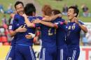 Japan's Yasuhito Endo, second left, is embraced by teammates after scoring a goal during the AFC Asia Cup soccer match between Japan and Palestine in Newcastle, Australia, Monday, January 12, 2014. (AP Photo/Rob Griffith)