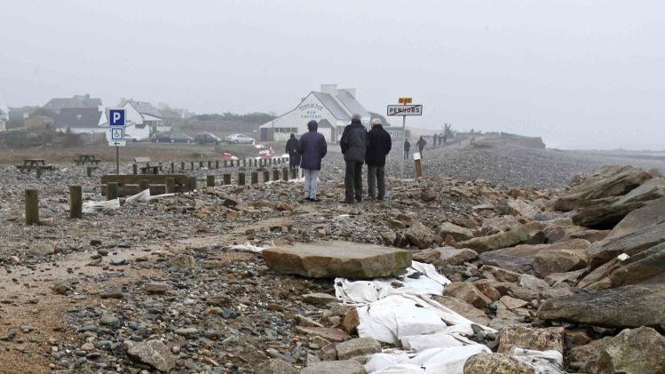 People survey the devastated sea-front following Atlantic storms at 