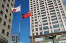 A Chinese national flag and a Japanese national flag fly outside buildings in the Chinese city of Dalian, December 31, 2012