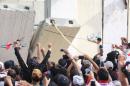 Iraqi protesters open a breach in a concrete wall surrounding the parliament on April 30, 2016
