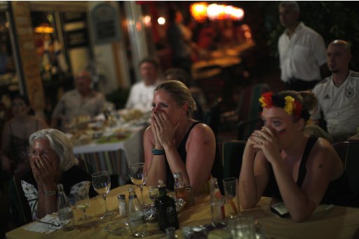 Germany soccer fans react at the end of the Euro 2012 semi-final match between Italy and Germany as they watch the match on television at a restaurant in Fuengirola