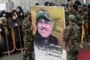 Hezbollah fighters carry a portrait of Mustafa Badreddine during his funeral in the Ghobeiry neighbourhood of Beirut on May 13, 2016