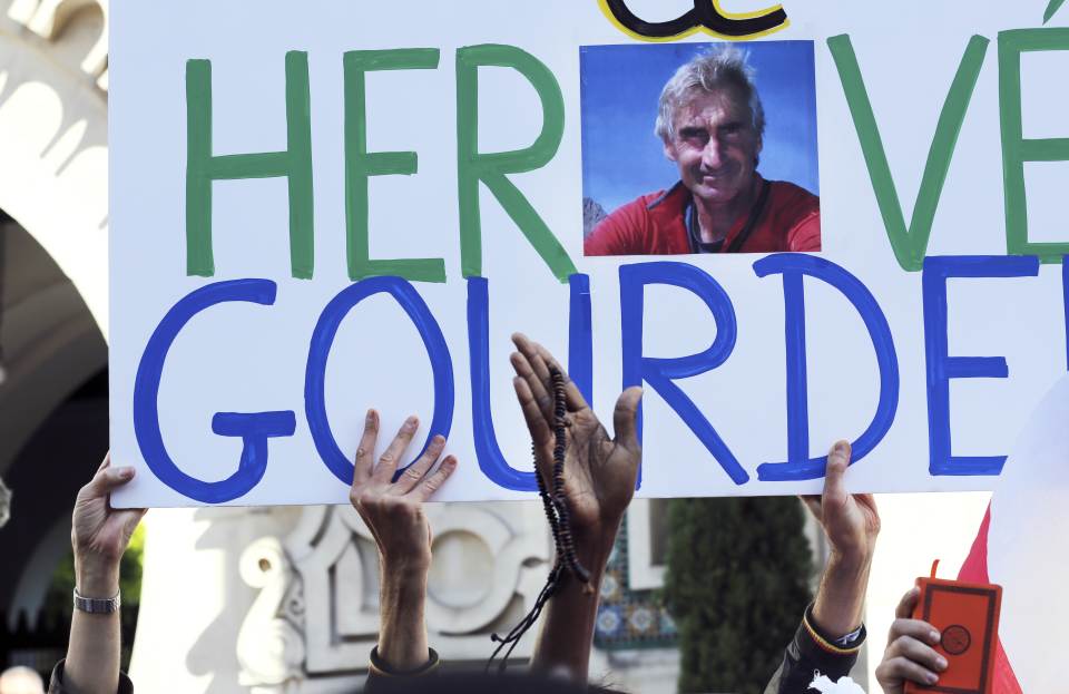 Muslims hold a sign paying homage to French mountaineer Hervé Gourdel, his photo in the centre of the banner, who was beheaded by Islamist militants...