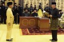 In this photo released by the Malaysian Information Department, Malaysian King Tuanku Abdul Halim, left, watches Prime Minister Najib Razak take his oath of office at the National Palace in Kuala Lumpur, Monday, May 6, 2013. Malaysia's long-governing coalition, Razak's National Front coalition, won the national election with a weakened majority to extend its unbroken 56-year rule. (AP Photo/Malaysian Information Department, Wazari Wazir) EDITORIAL USE ONLY, NO SALES