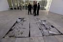 Policemen are pictured near damaged tiles inside the Bardo museum in Tunis