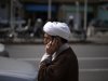 A cleric talks on his mobile phone as he arrives at a religious conference centre in Qom