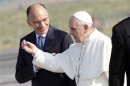 Pope Francis gestures as he talks with Italy's Prime Minister Letta before boarding a plane at Fiumicino airport in Rome