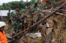 Bangladeshi soldiers clear debris while searching for bodies after a landslide in Chittagong