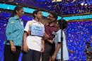 Arvind Mahankali, 13, of Bayside Hills, N.Y., is congratulated by his family as confetti falls after he won the National Spelling Bee by spelling the word "knaidel" correctly on Thursday, May 30, 2013, in Oxon Hill, Md. (AP Photo/Evan Vucci)