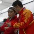 China's Guo Wenjun listens to her coach during the women's 10m Air Pistol qualification competition at the London 2012 Olympic Games