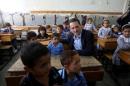 Pierre Krahenbuhl, UNRWA Commissioner-General, sits with Palestinian students inside a classroom as he visits a UN-run school on the first day of a new school year in Khan Younis in the southern Gaza Strip