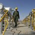 FILE - In this Tuesday, April 15, 2008 file photo, Iranian oil technician Majid Afshari makes his way to the oil separator facilities in Iran's Azadegan oil field southwest of Tehran. Iran has stored up imported goods and hard currency for a "battle" against EU sanctions targeting the country's vital oil sector that went into effect Sunday, officials said. They acknowledged though that the measures, which aim at pressuring the Islamic Republic over its nuclear program, may cause economic disruptions. (AP Photo/Vahid Salemi, File)