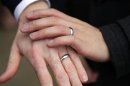 Bernie Liang and Ryan Hamachek show their rings after getting married outside Seattle City Hall