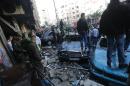 Onlookers and security forces gather at the scene of car bomb explosion in Beirut's southern suburbs on January 21, 2014