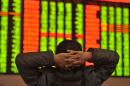 A Chinese investor sits in front of a screen showing stock market movements in Fuyang, Anhui province, on January 4, 2016