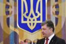 Ukrainian President Petro Poroshenko speaks to the press in front of Ukraine's state coat of arms following talks with the European Commission president in Kiev on September 12, 2014